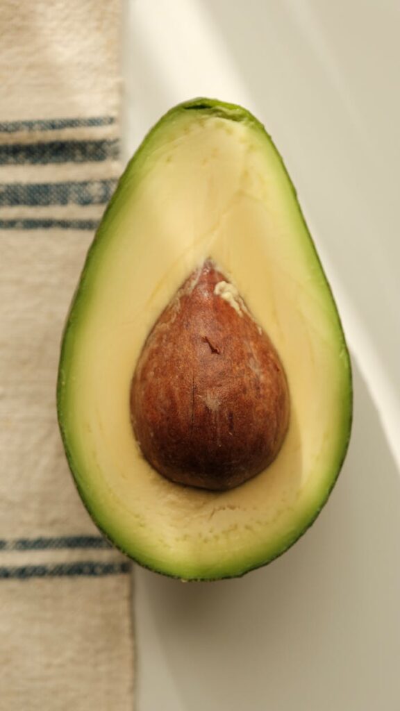 Close-up of a ripe avocado sliced in half showcasing its seed.